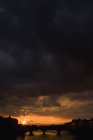 Cielo fangoso al tramonto sulla silhouette del ponte — Foto stock