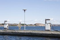 Petrol pumps on pier over water — Stock Photo