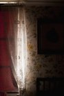 Detalhe do interior antiquado com papéis de parede estampados florais e cortinas na janela — Fotografia de Stock
