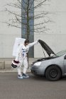 Un astronauta con problemas de coche - foto de stock