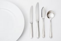Diverse posate e utensili da cucina su superficie grigia — Foto stock