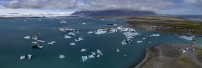 Vista panoramica degli iceberg in acqua contro il cielo nuvoloso — Foto stock