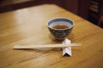 Still life of chopsticks and bowl on wooden table — Stock Photo