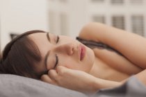 Young woman sleeping on bed at home — Stock Photo