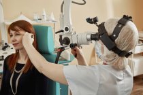 Médico examinando el oído de la paciente femenina en el hospital - foto de stock