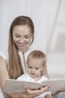 Felice madre e figlia lettura libro a casa — Foto stock