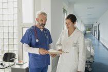 Medici che discutono la cartella clinica nel corridoio ospedaliero — Foto stock