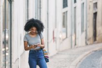 Молодая женщина использует смартфон на городской улице — стоковое фото