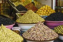 Abundante variedad de aceitunas frescas en exhibición en el puesto del mercado del zoco, Marrakech, Marruecos - foto de stock