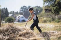 Ragazzo in tuta da lavoro in fattoria soleggiata — Foto stock
