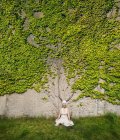 Portrait de femme méditant au mur envahi de lierre — Photo de stock