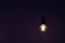 Урожай електрична лампочка висвітлюється на чорному фоні — стокове фото