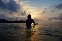 Surfista di silhouette seduto su tavola da surf in un tranquillo oceano al tramonto, Sayulita, Nayarit, Messico — Foto stock
