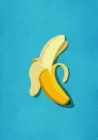 Banana sbucciata su sfondo blu — Foto stock