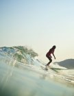 Surfista feminina cavalgando onda oceânica — Fotografia de Stock