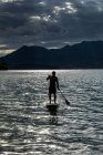 Silhouette of man paddle boarding on sunny, idilliaco lake, Walchensee, Baviera, Germania — Foto stock