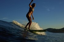 Surfista feminina cavalgando onda oceânica — Fotografia de Stock