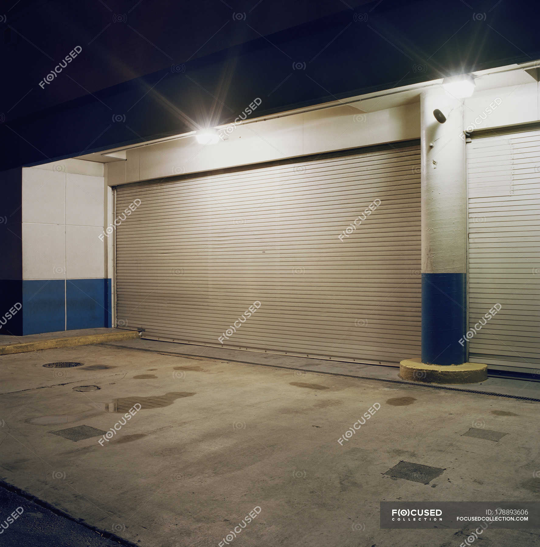 Floodlights Above Rolling Garage Doors At Loading Dock Building