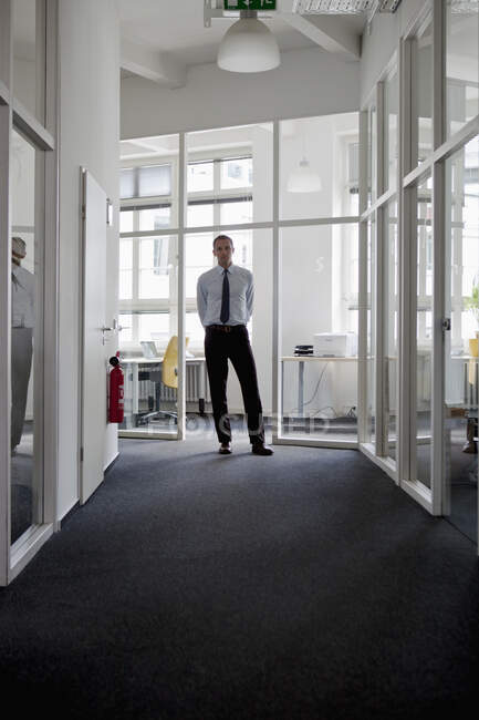 Um homem de negócios no fim de um corredor — Fotografia de Stock