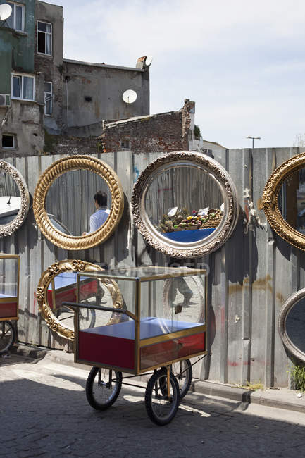Push carts and mirrors hanging on fence for sale at flea market — Stock Photo