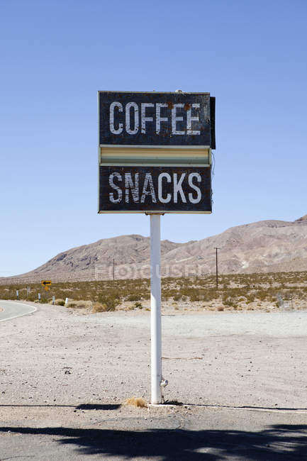 Señal de tráfico que anuncia café y aperitivos en la carretera del desierto - foto de stock
