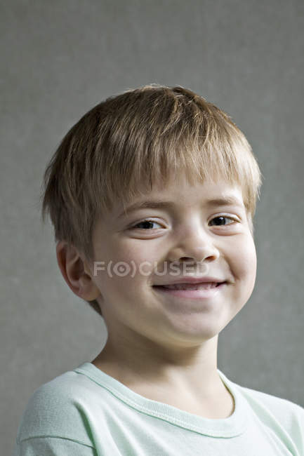 Portrait de garçon souriant sur fond gris — Photo de stock