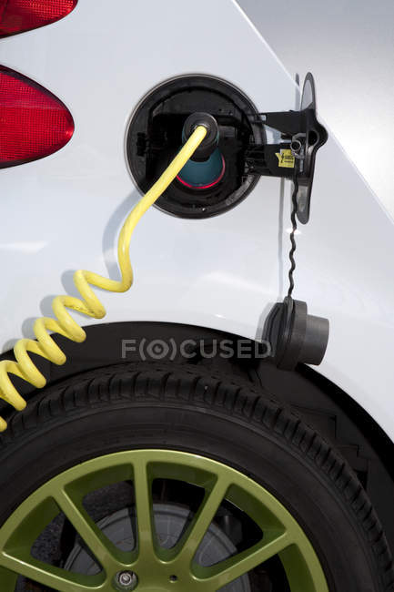 Electric charger connected to electric car recharging plug — Stock Photo