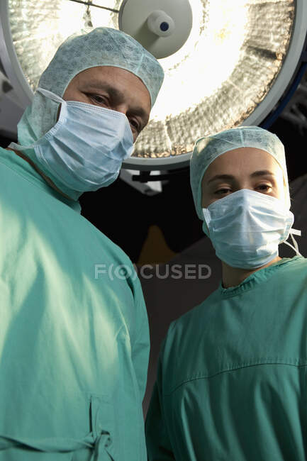 Dos personal de cirugía de pie en un quirófano - foto de stock