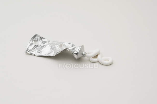 Pasta de dientes exprimida del tubo de metal — Stock Photo