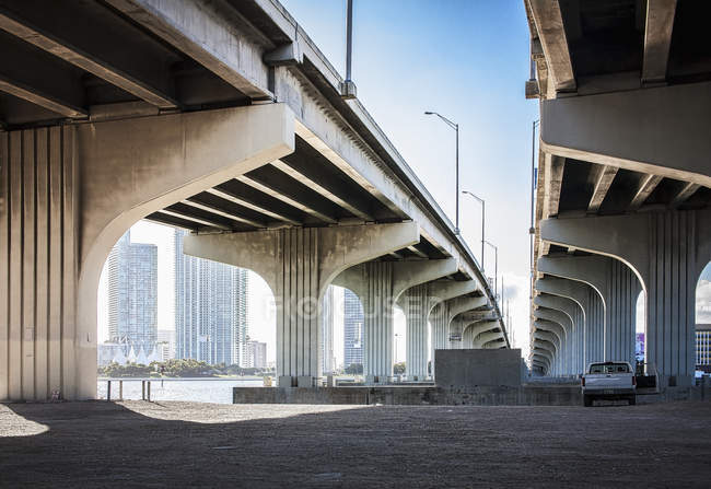 Underneath view of highway bridges and parked care — Stock Photo