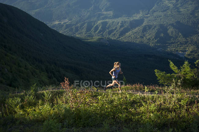 Mulher correndo no caminho da montanha no verão — Fotografia de Stock