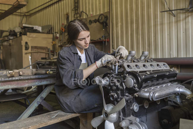 Mecánica femenina reparación de motor de coche en el garaje - foto de stock