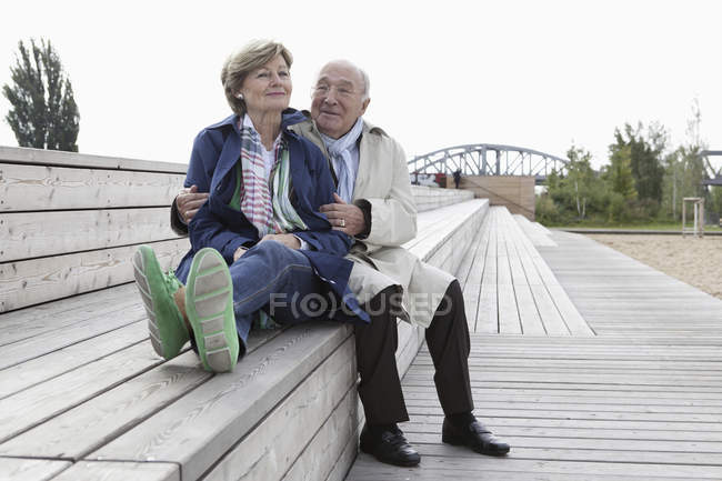 Paar sitzt auf Holztreppe im Park — Stockfoto
