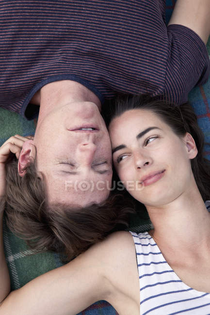 Gros plan du jeune couple allongé sur une couverture de pique-nique — Photo de stock