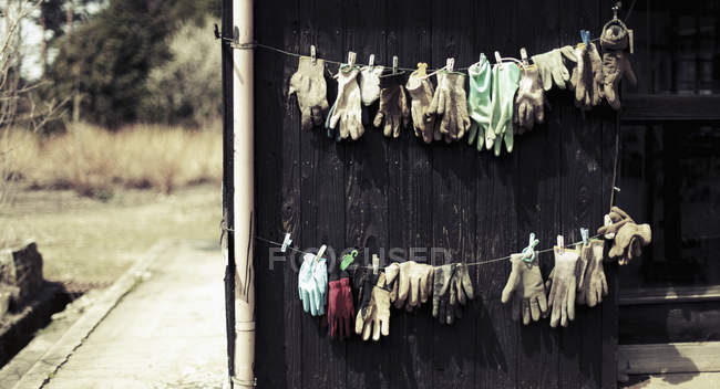 Перчатки высыхают на бельевой веревке во дворе — стоковое фото