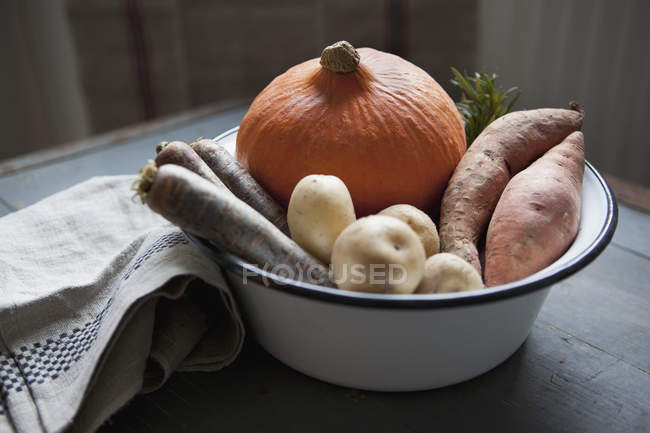 El primer plano de hortalizas frescas en la escudilla a la mesa - foto de stock