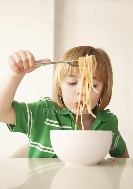 A boy eating spaghetti — Stock Photo