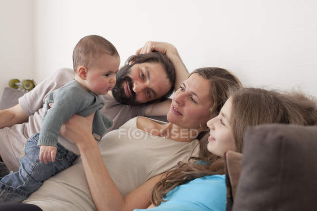 Family looking at baby girl in living room — Stock Photo