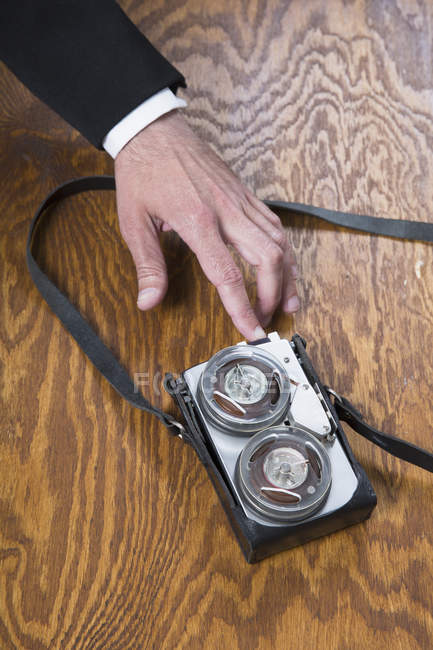 Cosecha mano masculina usando grabadora de cinta anticuada en mesa de madera - foto de stock