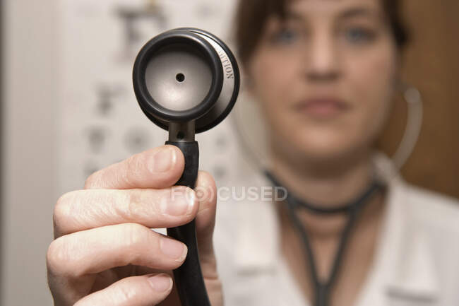 Un médico usando un estetoscopio - foto de stock