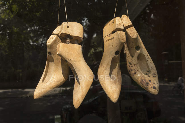 Primer plano de esculturas de tacón alto de madera colgando en la tienda - foto de stock