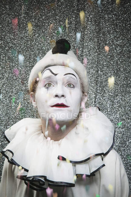 Клоун, наблюдающий за падением конфетти на сцене — стоковое фото