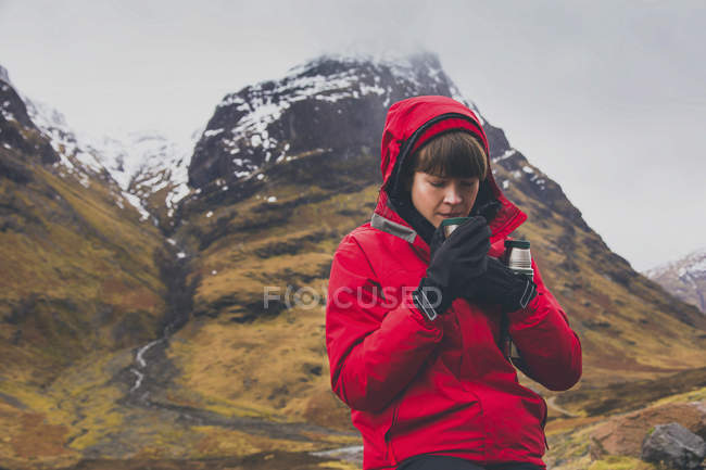 Femme buvant du café contre la montagne pendant l'hiver — Photo de stock