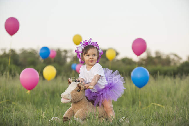 Немовля з туту на гойдалці в полі з кульками. — стокове фото
