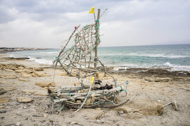 Bote de madera naufragio en la playa de arena contra el paisaje marino - foto de stock