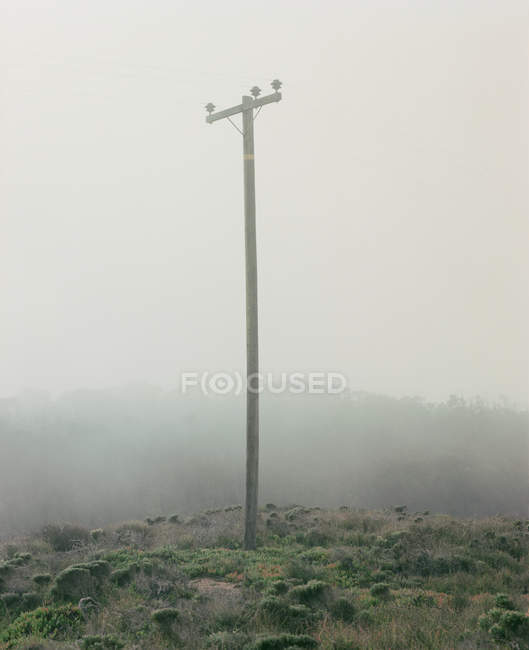 Pilone elettrico in collina in condizioni di nebbia — Foto stock