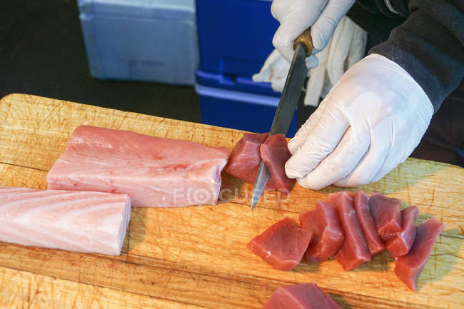 Vista de alto ángulo del carnicero cortando carne a bordo en la tienda, Tokio, Japón - foto de stock