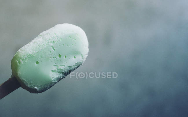 Vista de cerca del helado verde en palo - foto de stock