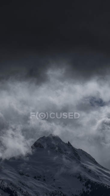 Low angle view of snowcapped mountain against cloudy sky, Tantalus, British Columbia, Canada — Stock Photo