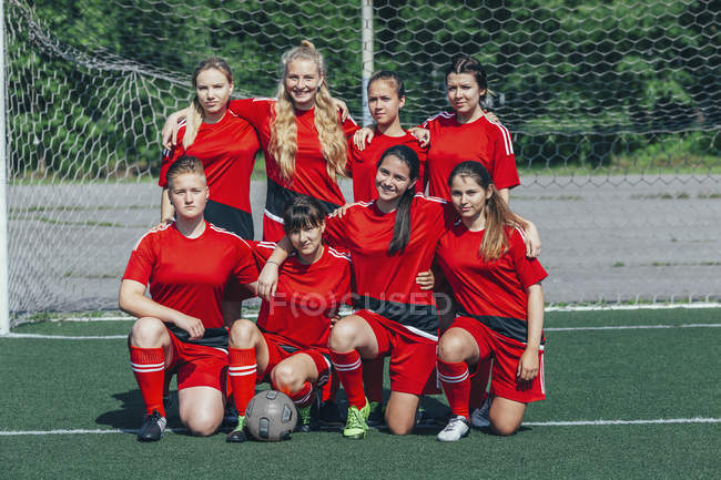 Portrait Of Soccer Team On Field Against Net Happiness Teenage Girls Stock Photo